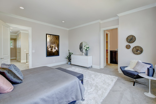 A bedroom with white walls and carpets